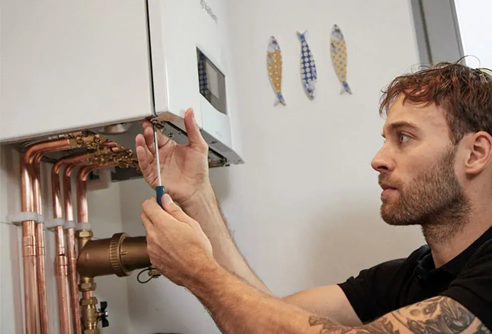 Heating engineer repairing a boiler in a Sheffield home