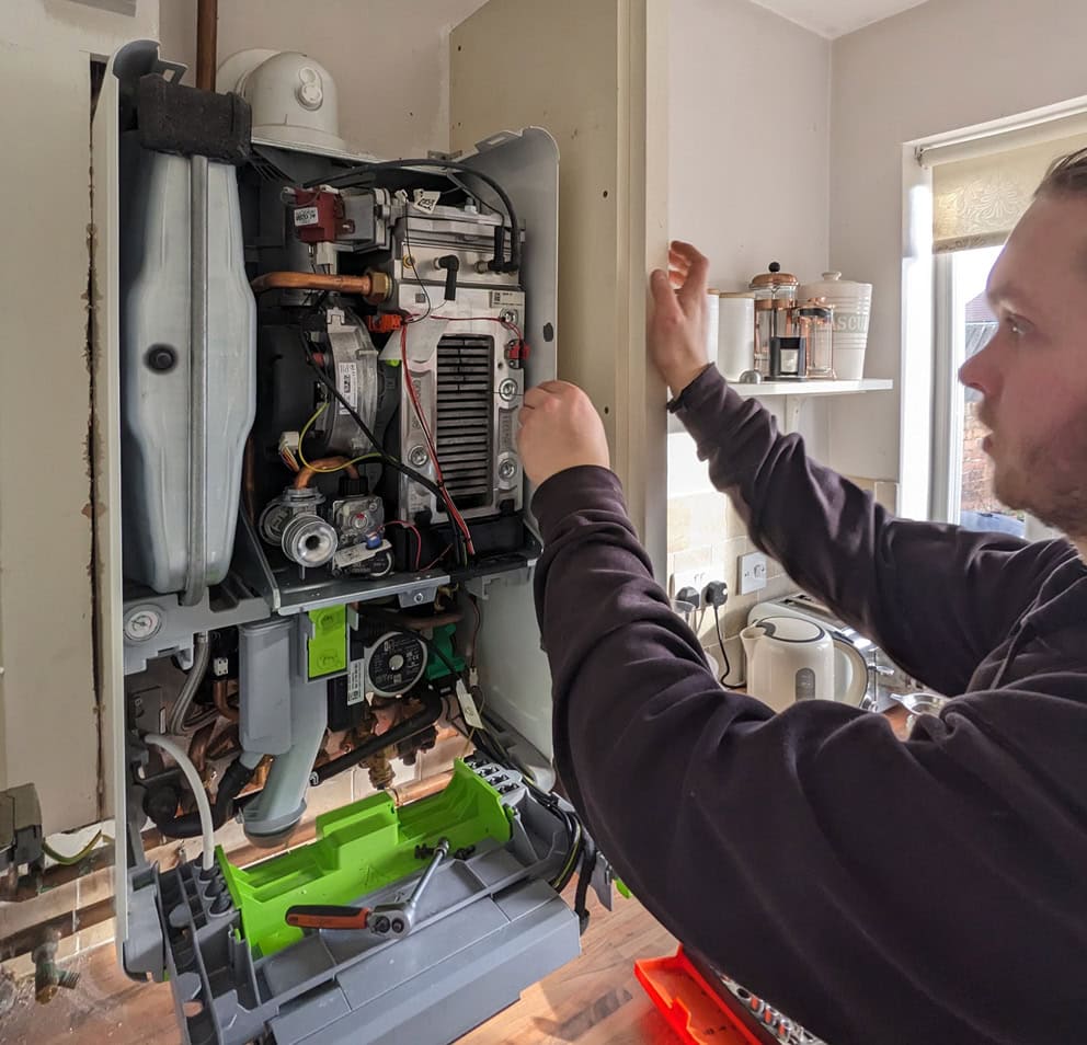 Heating engineer checking the inside of a boiler in a Sheffield home