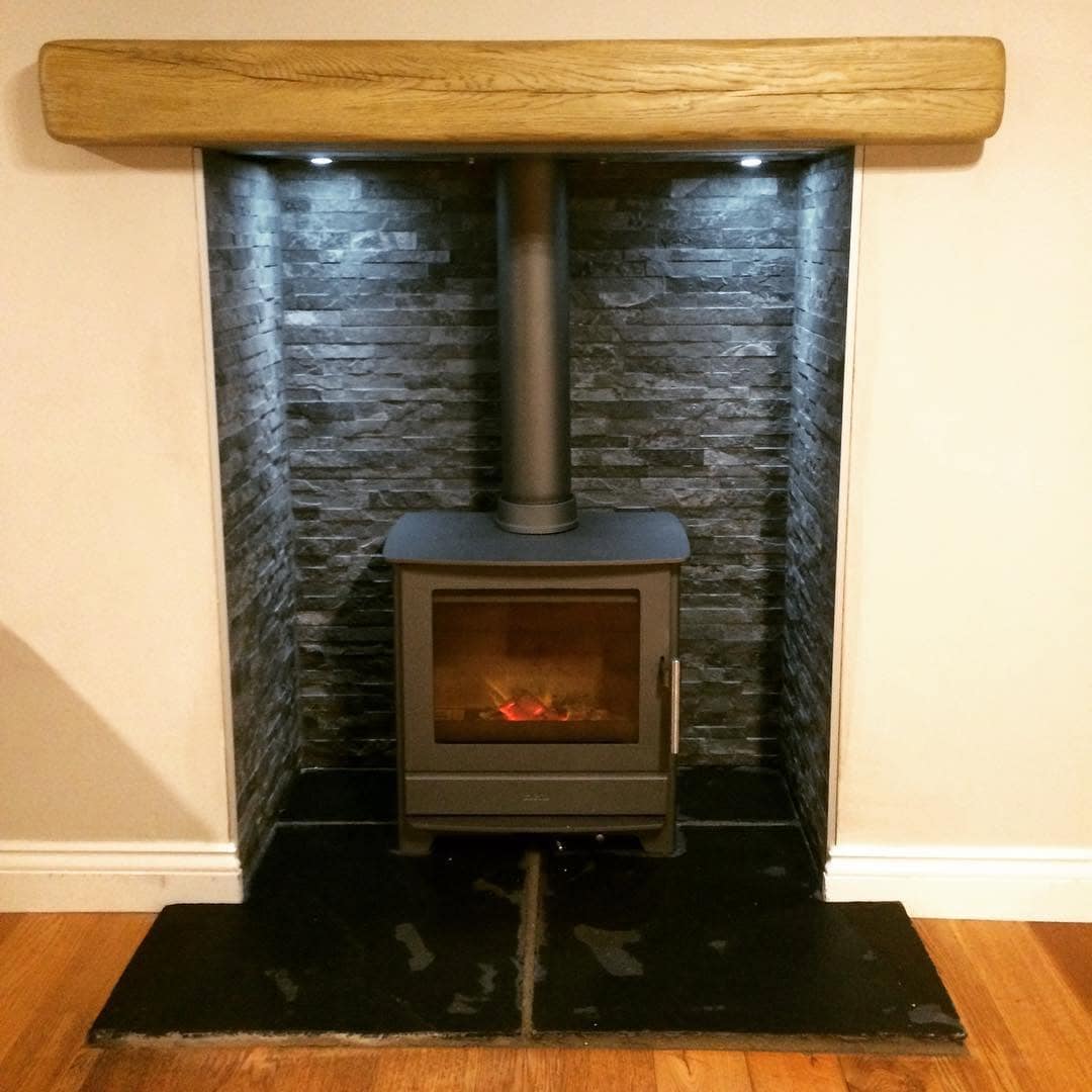 Wood burning stove installed in a brick fireplace